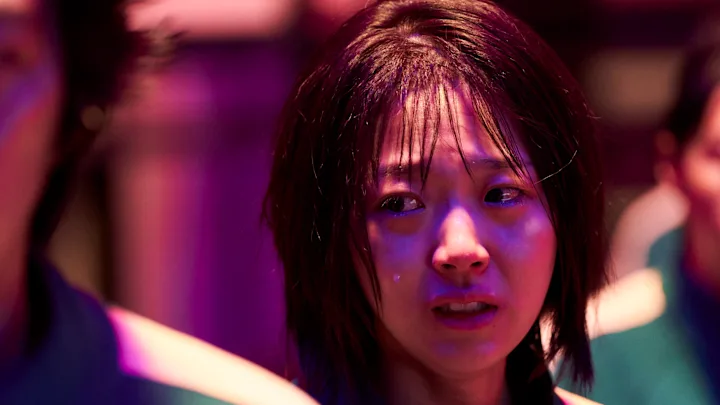 a woman crying in a purple light - episódio 6 da 2ª temporada de Round 6